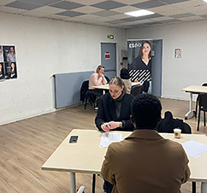 2 étudiants assis à une table avce en fond un kakemono de esgci 2 étudiants assis à une table avce en fond un kakemono de esgci