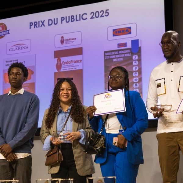Quatre étudiants sur la scène lors d'une remise de prix