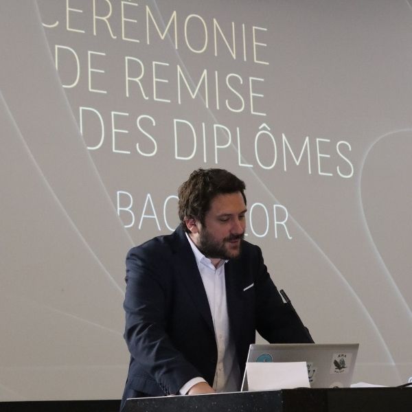 Une homme brun en costume fait un discours