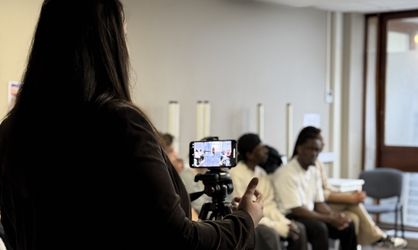 Femme brune film un personne avec son téléphone portable